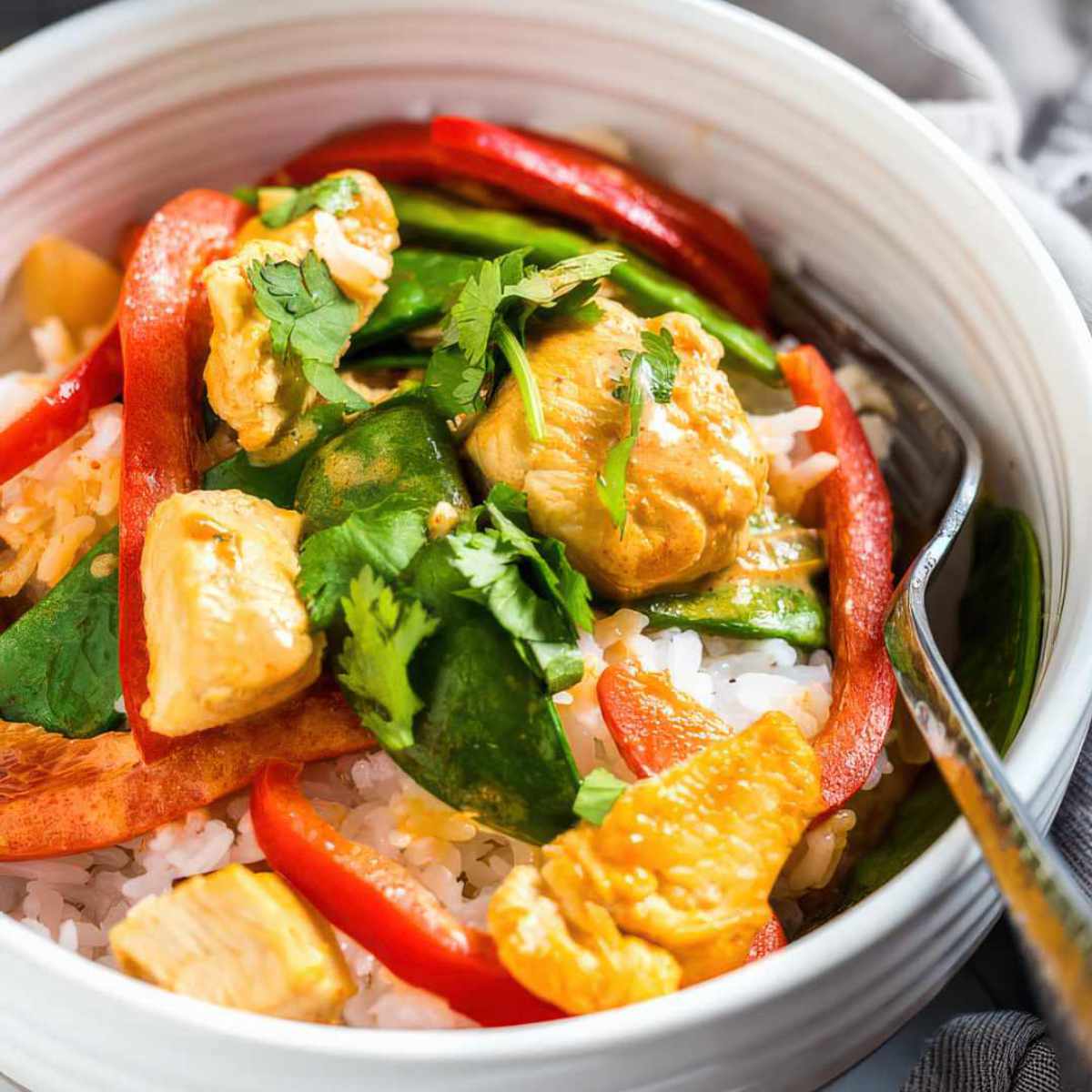 Close up of creamy coconut chicken curry with tender chicken and vegetables in sauce