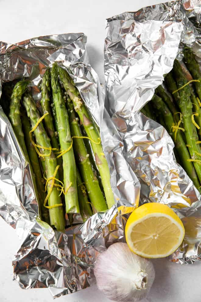 Asparagus with lemon slices and lemon zest in foil.