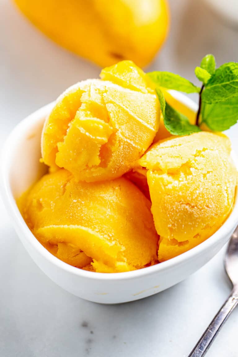 Close up of mango sorbet scoops showing smooth texture and vibrant color