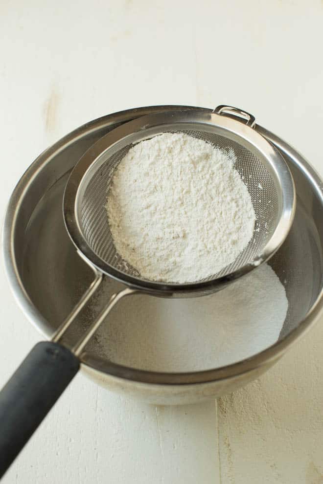 Sifting cake flour with a mesh sieve.