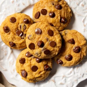 a plate with five soft pumpkin chocolate chip cookies