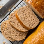 four slices of whole wheat bread on a cooling rack on the counter