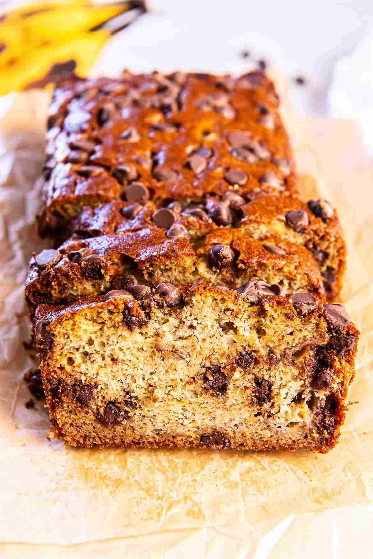 Close-up of sliced chocolate chip banana bread showing a moist, tender crumb studded with melted chocolate chips.
