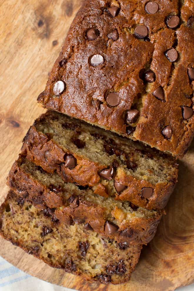 Three slices of banana bread on a wood cutting board