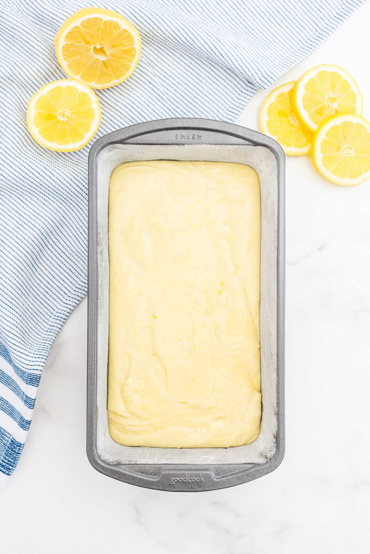 Lemon loaf cake batter spread evenly in a greased loaf pan before baking.