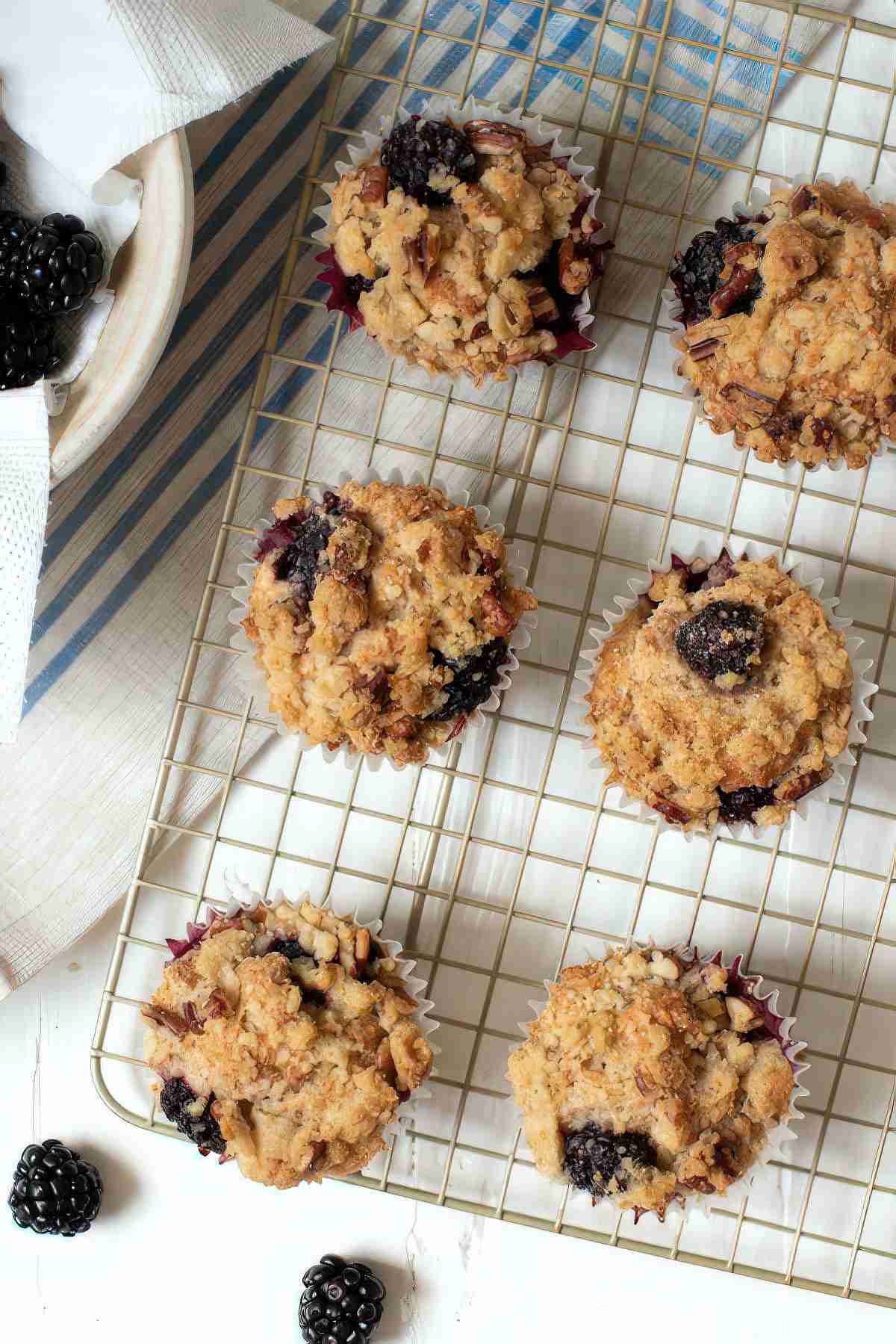 Overhead view of blackberry muffins with crumb topping cooling on a wire rack