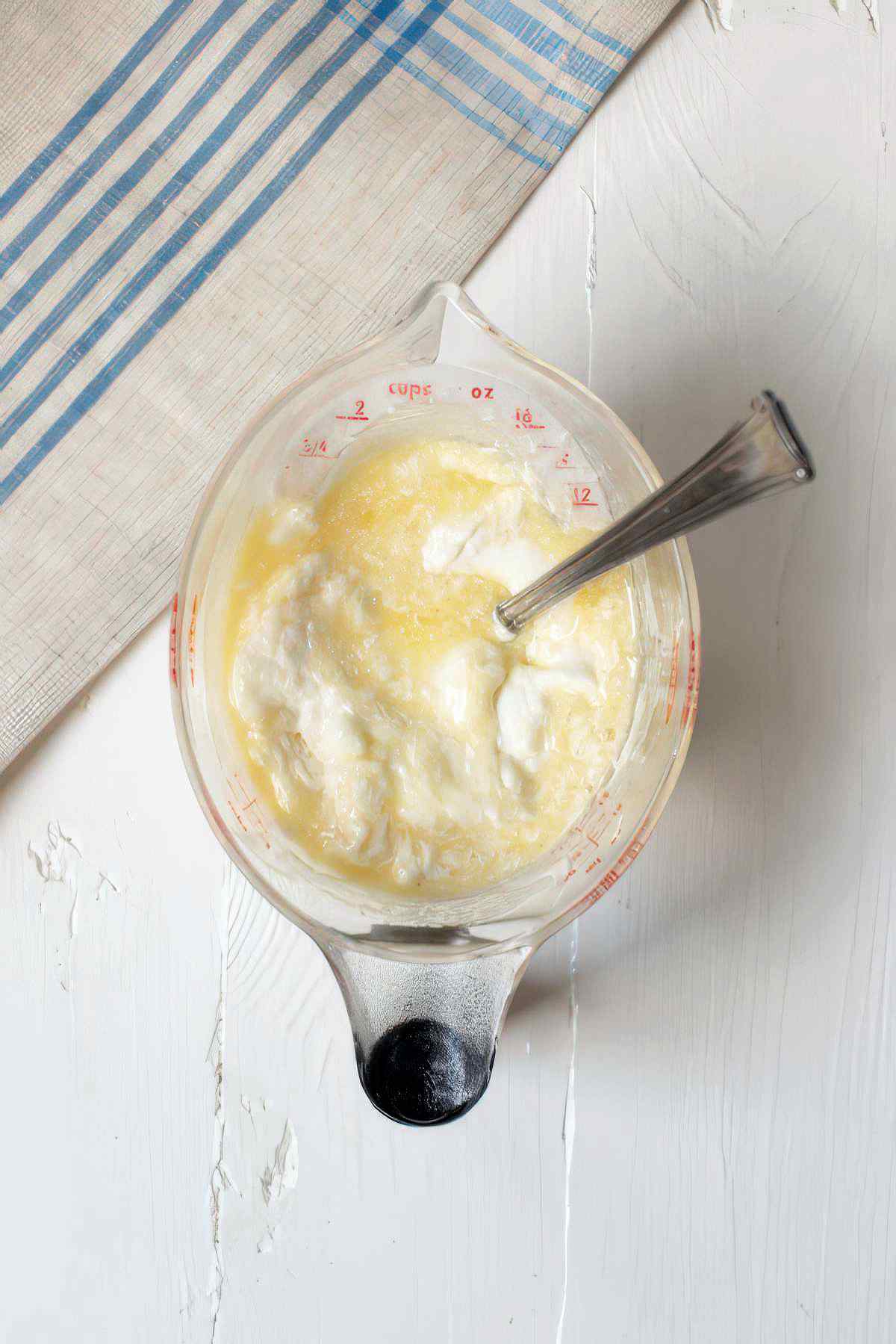 Mixing wet ingredients including yogurt, butter, and egg for blackberry muffin batter