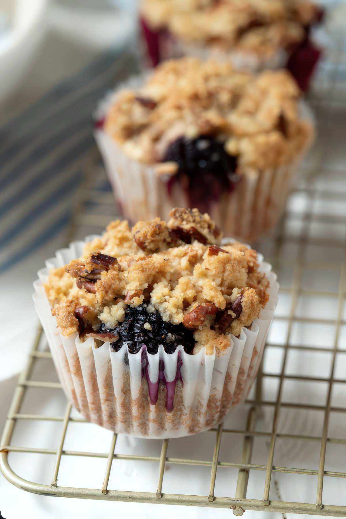 Close-up of a blackberry muffin with crumb topping showing juicy berries and golden streusel