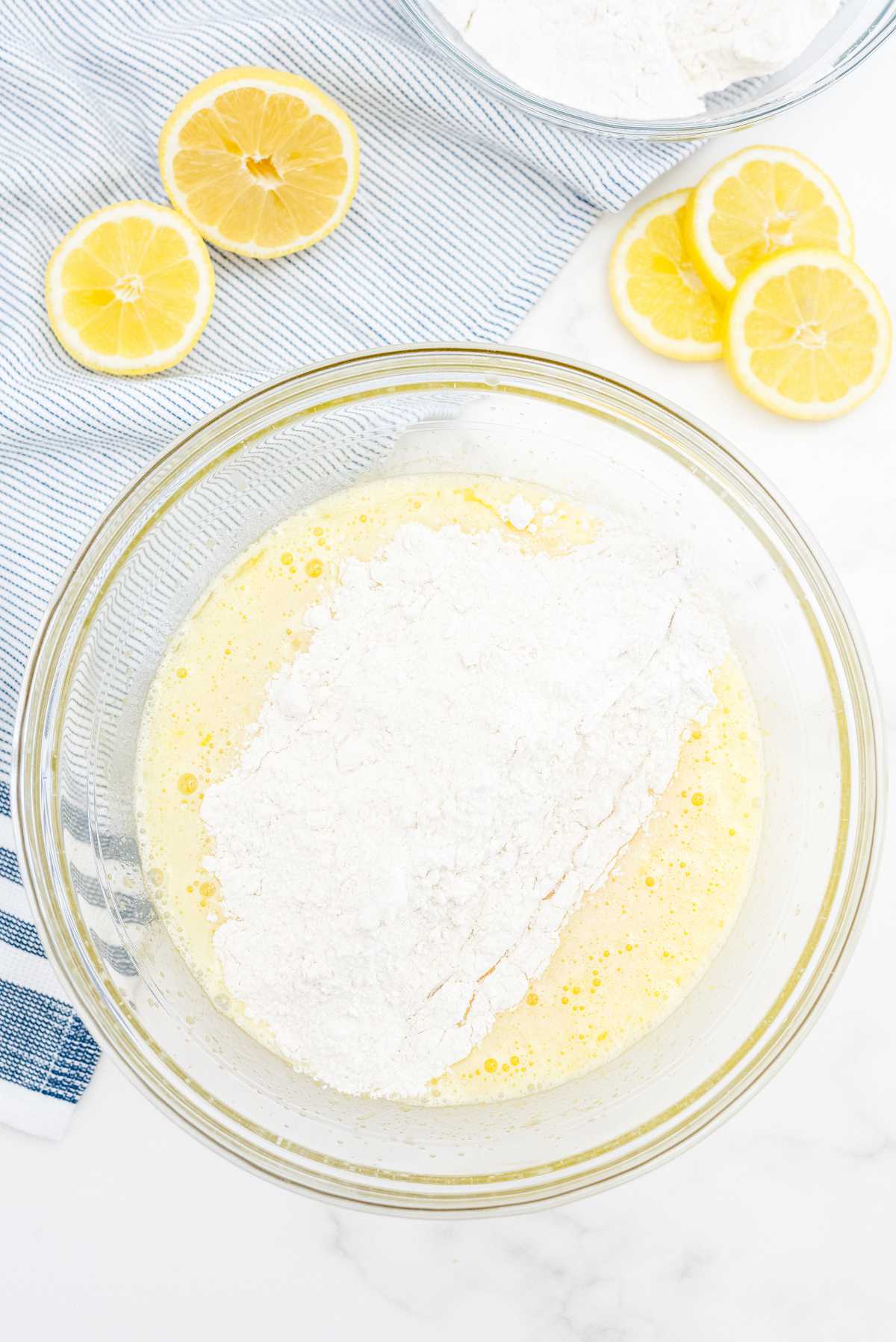 Flour being added to wet ingredients to make lemon loaf cake batter.