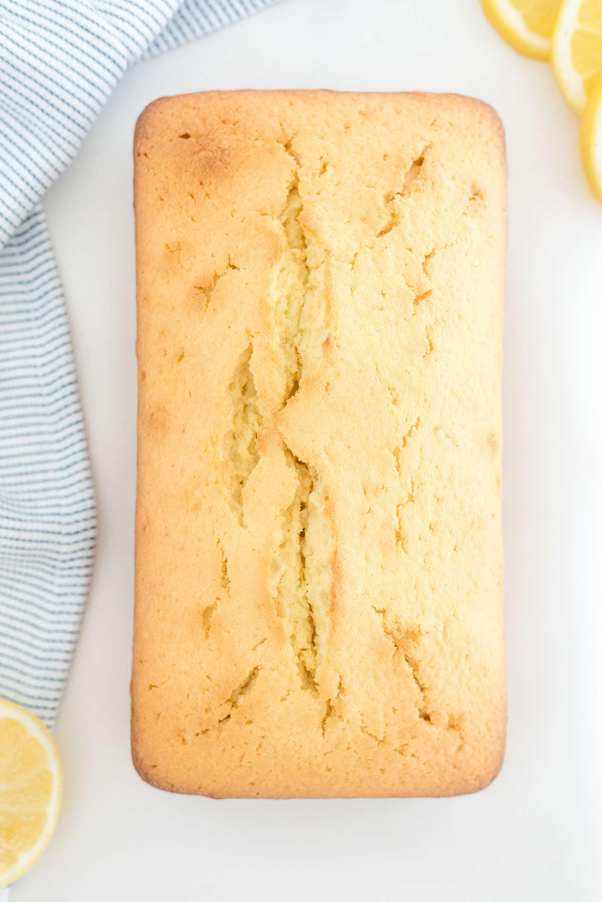 Freshly baked lemon loaf cake cooling after baking in a loaf pan.