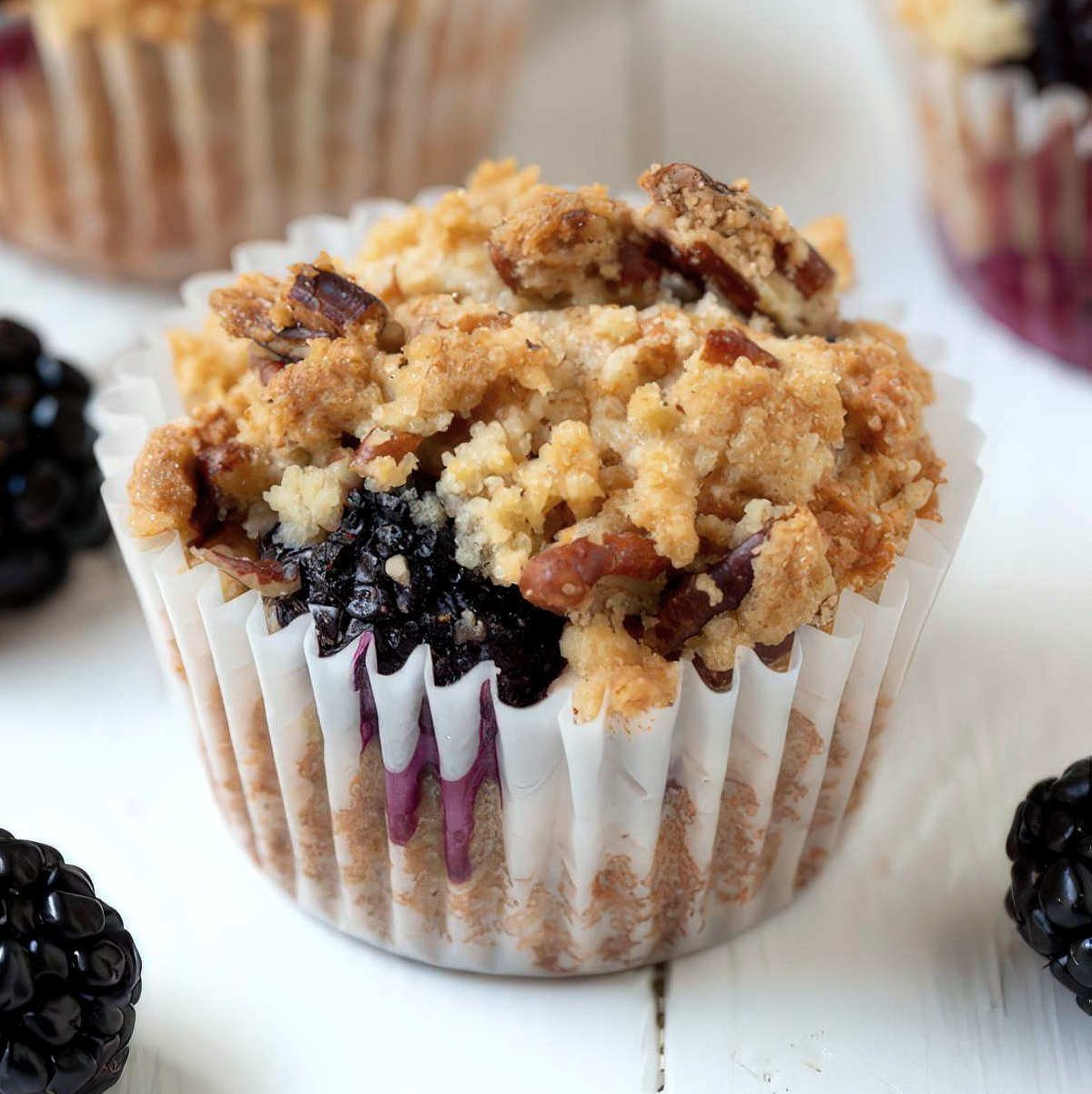 Easy blackberry muffin with crumble topping and visible juicy blackberry filling