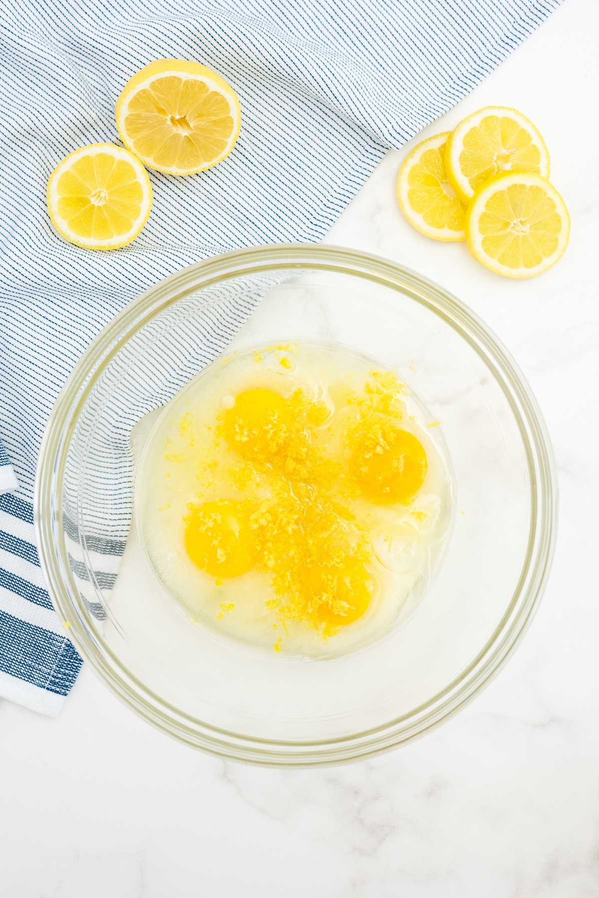 Eggs, lemon zest, and lemon juice mixed together for lemon loaf cake batter.