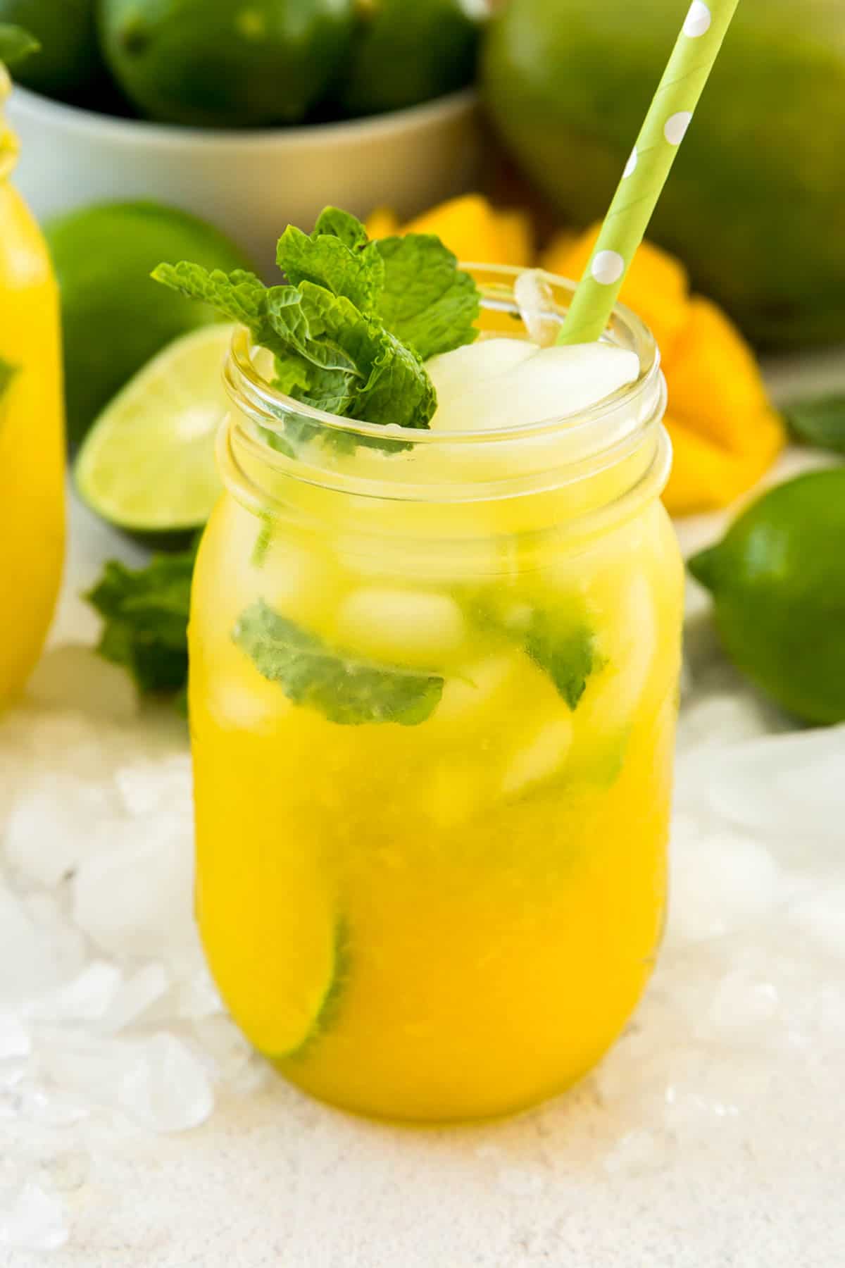 A mason jar filled with mango mojito and garnished with fresh mint leaves
