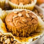 one pumpkin muffin sitting on a plate with pumpkin seeds on top