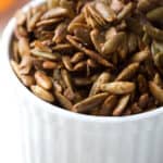 a white bowl filled with roasted pepitas