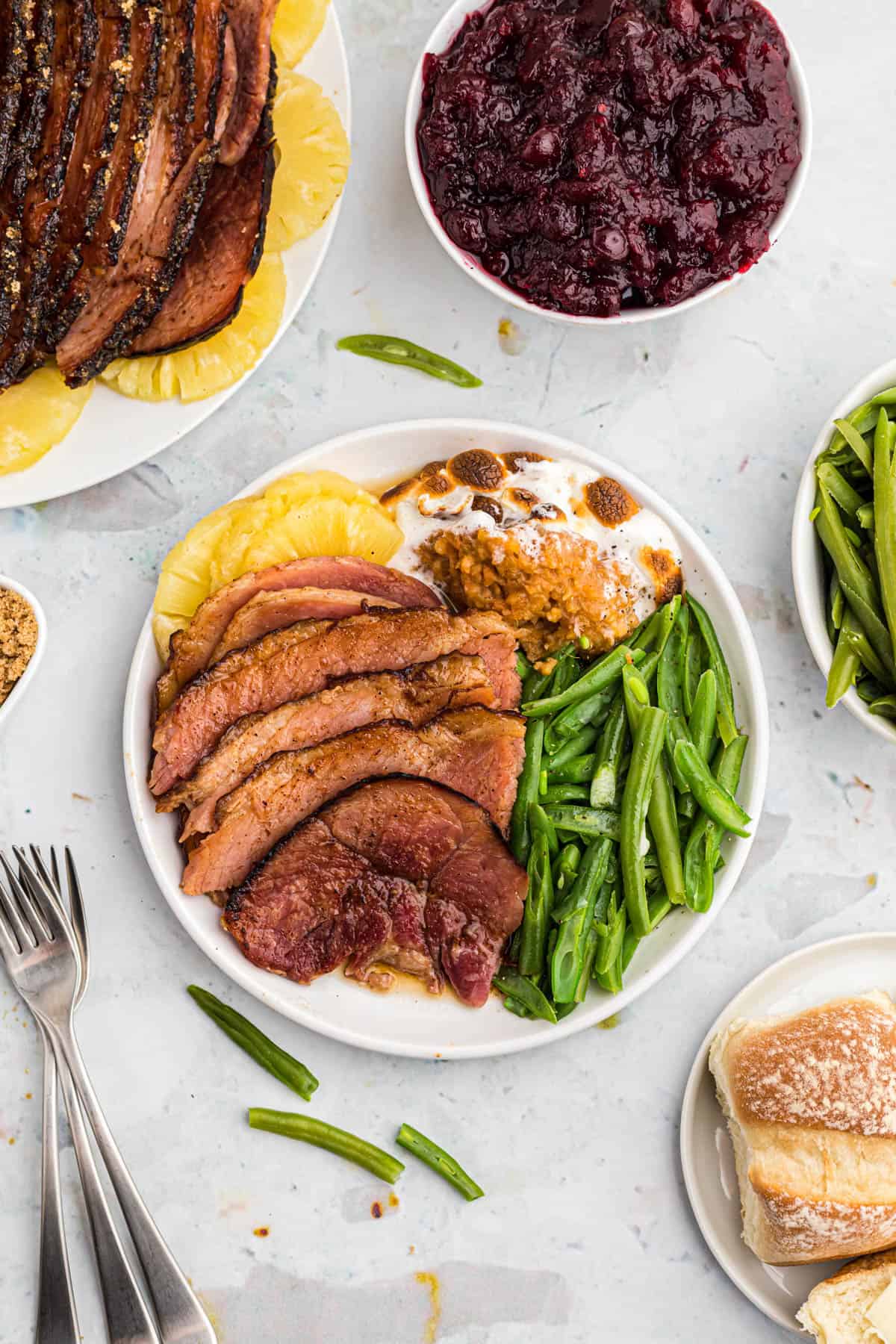 maple glazed ham served on a plate with green beans and sweet potato casserole