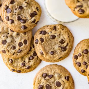 a pile of chocolate chip cookies on a white table