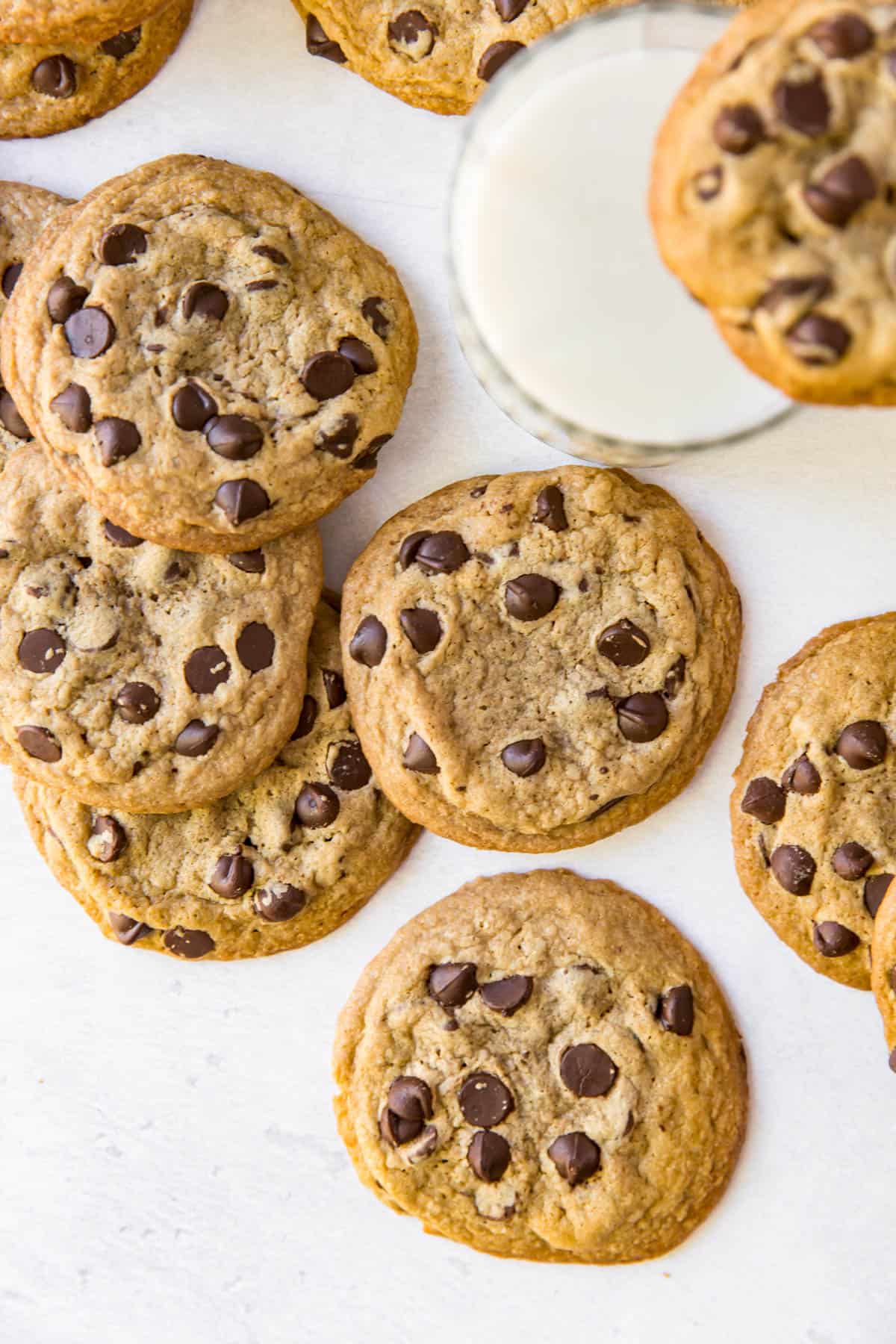 a pile of chocolate chip cookies on a white table