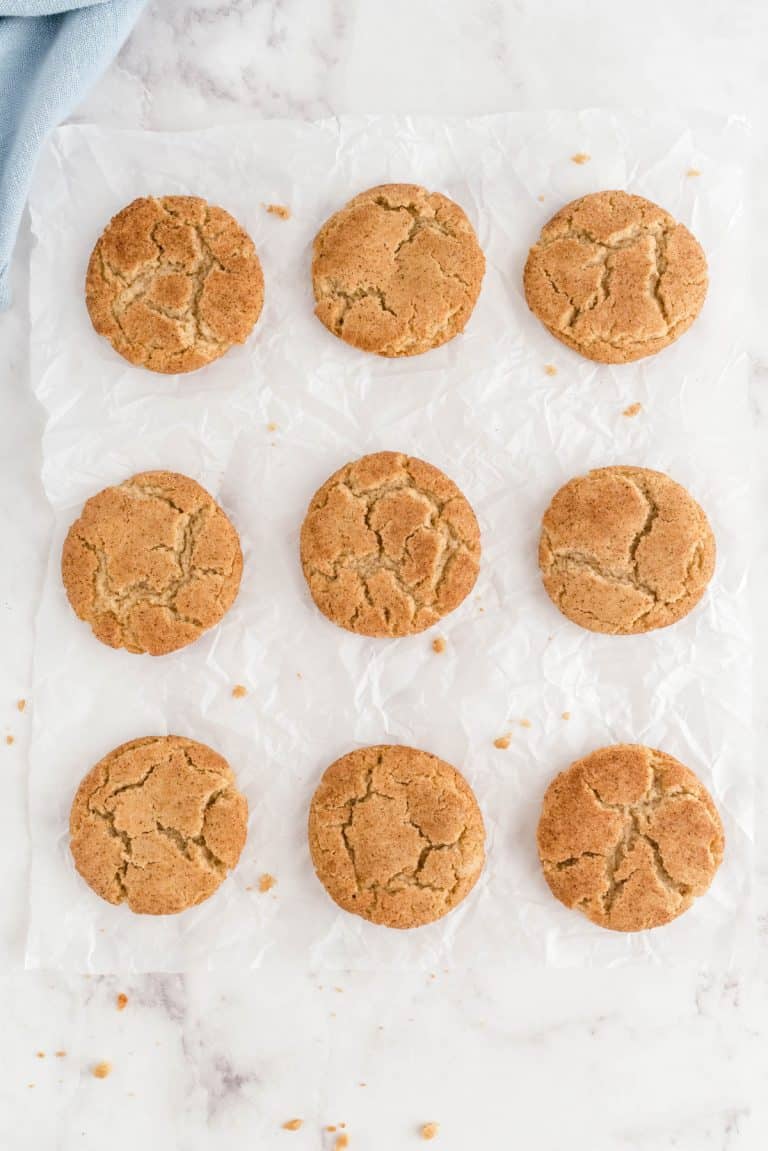 nine brown butter snickerdoodles sitting on a piece of white parchment paper