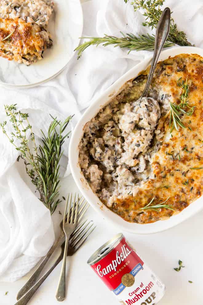 baked wild rice casserole sitting on a white table with a can of cream of mushroom soup