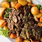 pot roast with potatoes and carrots on a white plate