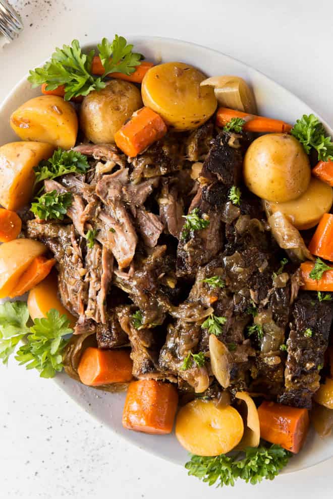 pot roast with potatoes and carrots on a white plate