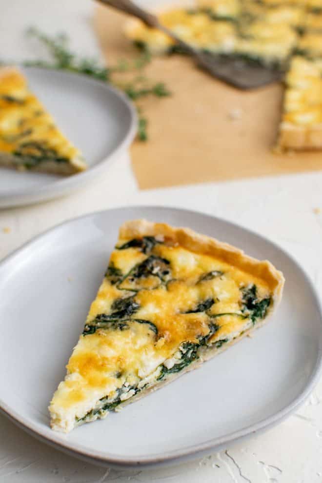 one slice of spinach and feta quiche on a plate
