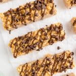 five chocolate chip peanut butter granola bars on a piece of white parchment paper