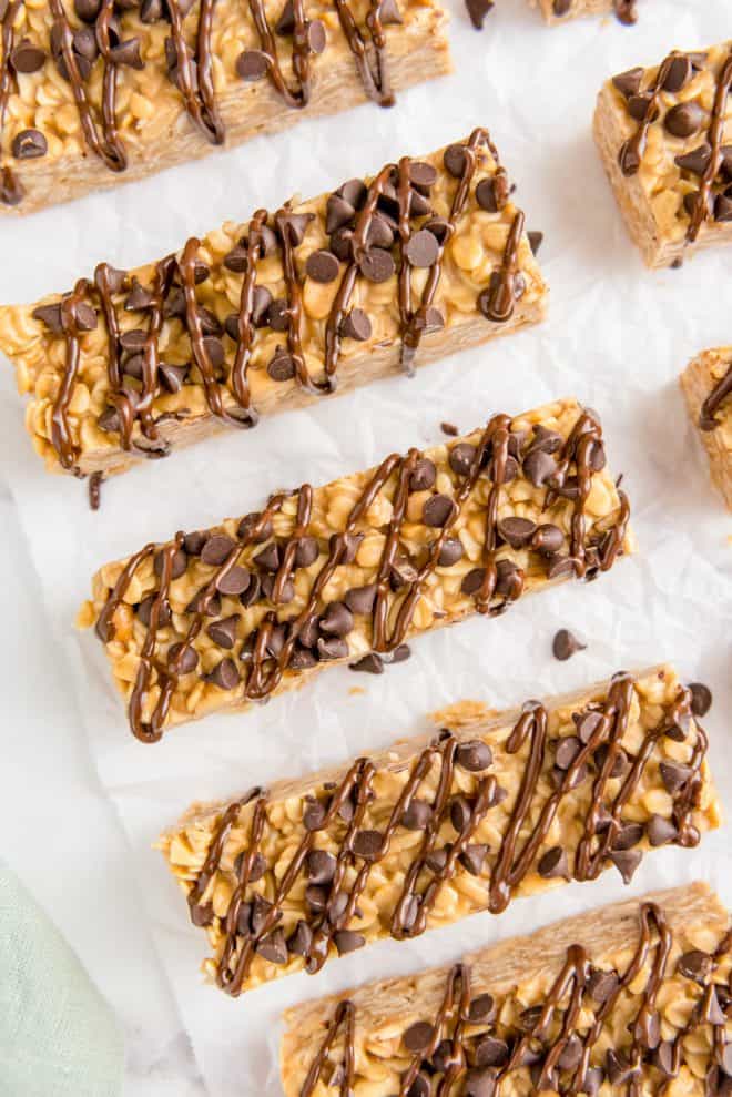 five chocolate chip peanut butter granola bars on a piece of white parchment paper