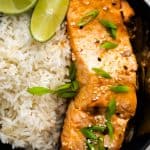 a slice of cooked sesame salmon on a plate with rice