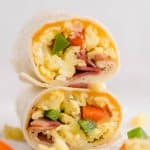 half of a breakfast burrito sitting on top of the other half