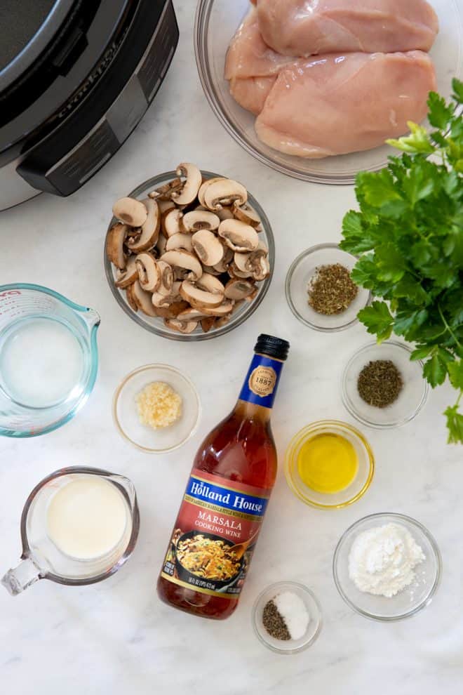 ingredients for slow cooker chicken marsala on a white tabletop