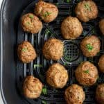cooked turkey meatballs in an air fryer basket