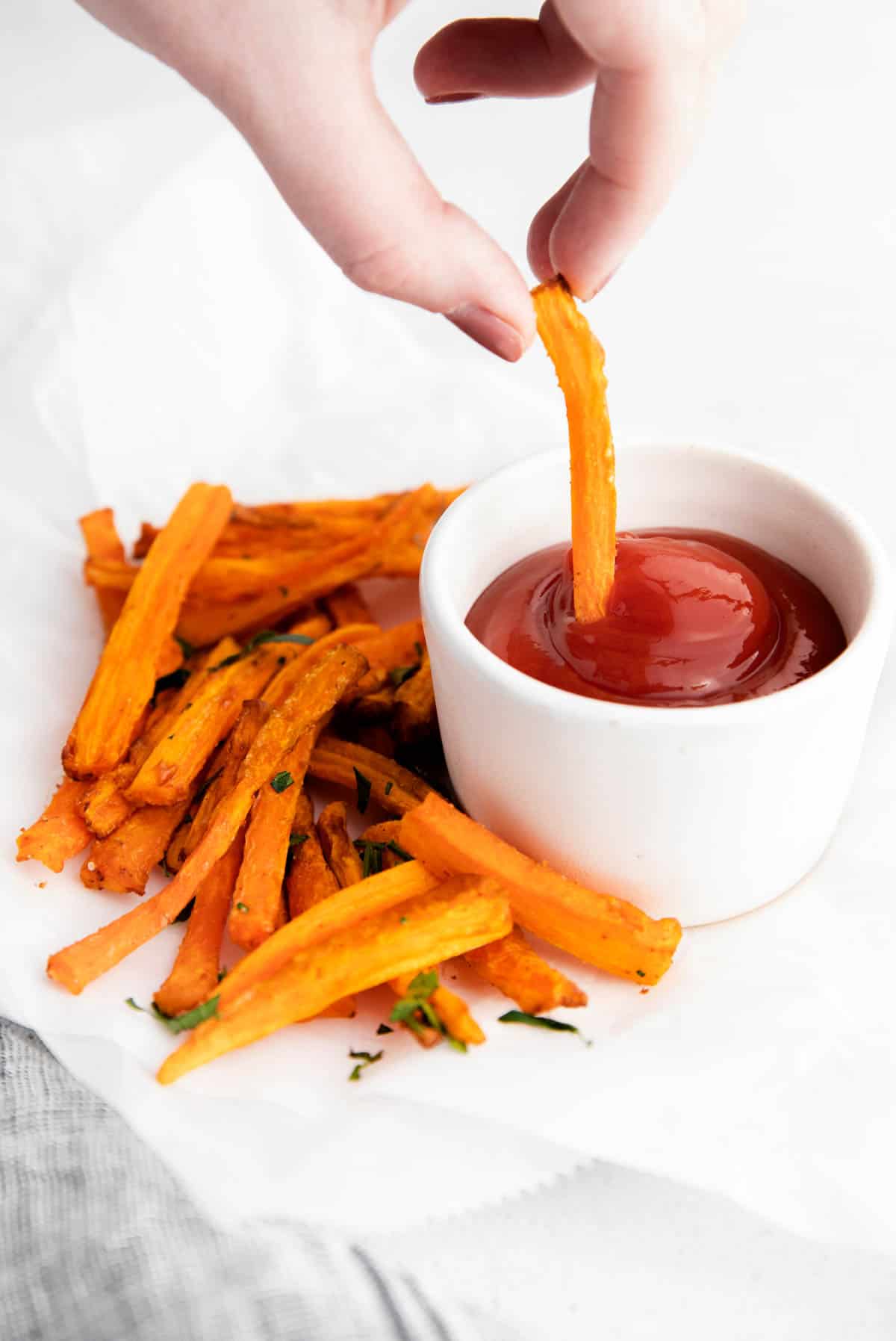 dipping a carrot fry into ketchup