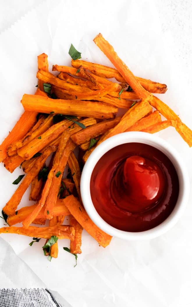 air fryer carrots sitting on a plate with a side of ketchup