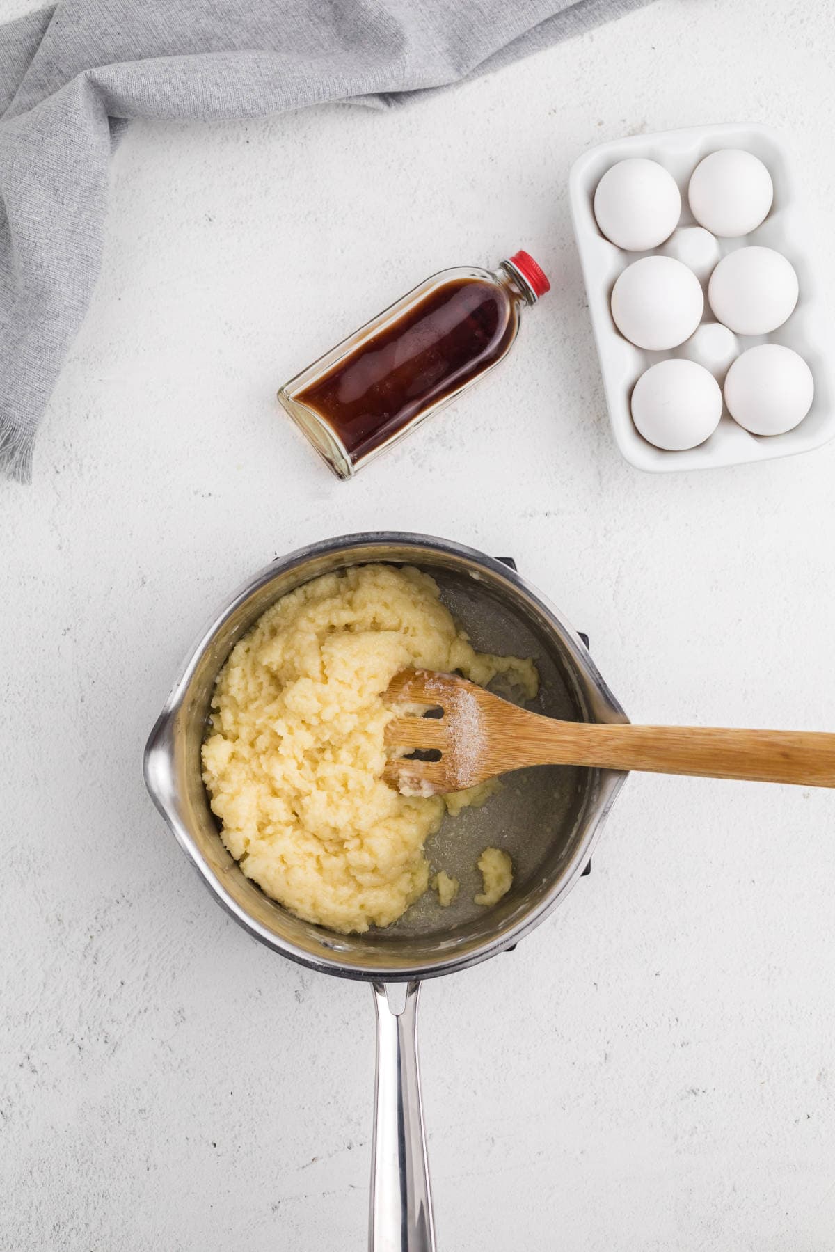 Choux pastry dough after flour is added, stirred until it forms a thick ball in the saucepan.