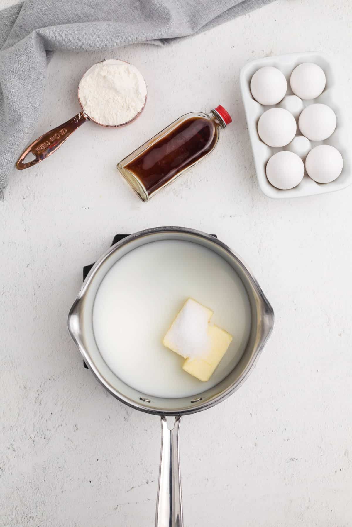 Butter, milk, water, and sugar melting together in a saucepan to start the choux pastry dough.