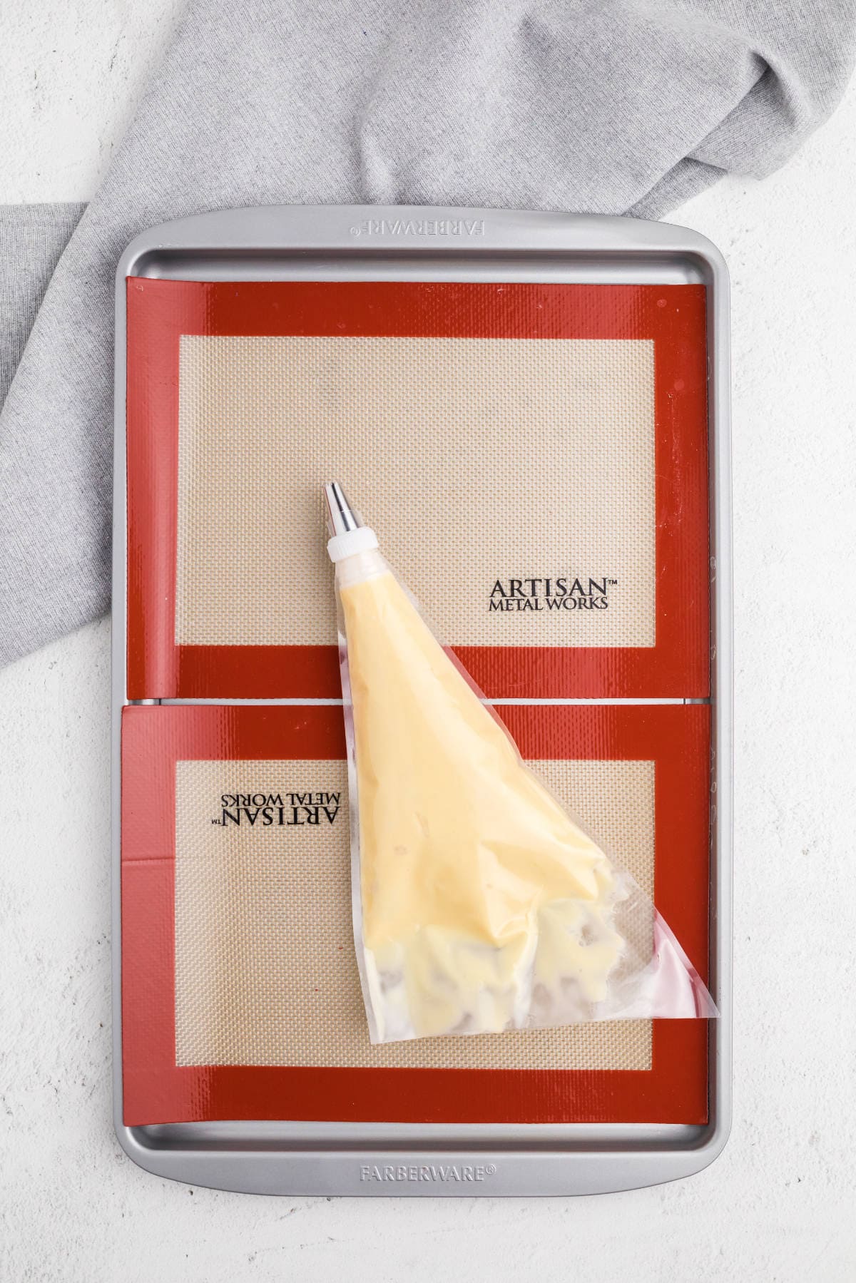 Prepared piping bag filled with choux pastry dough, ready to pipe eclair shapes.