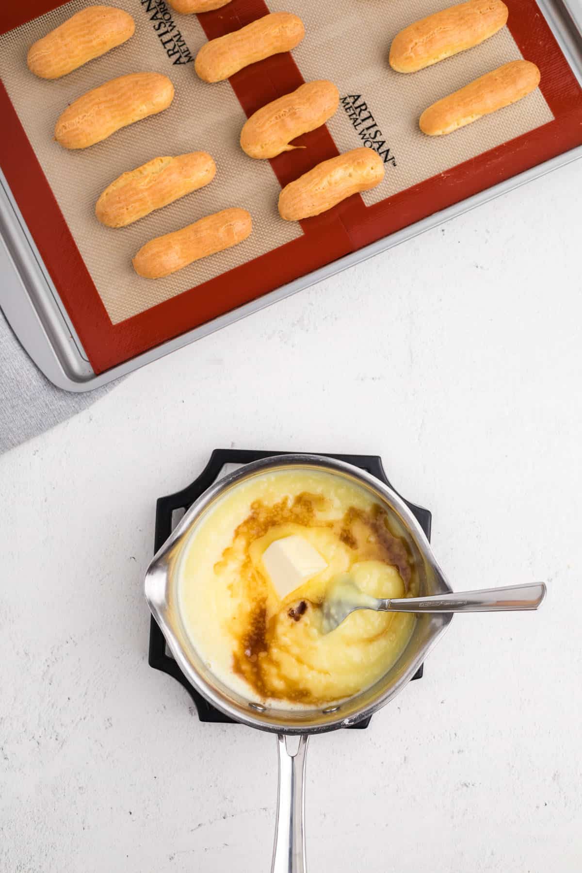 Vanilla pastry cream thickening on the stovetop with butter stirred in for a smooth texture.