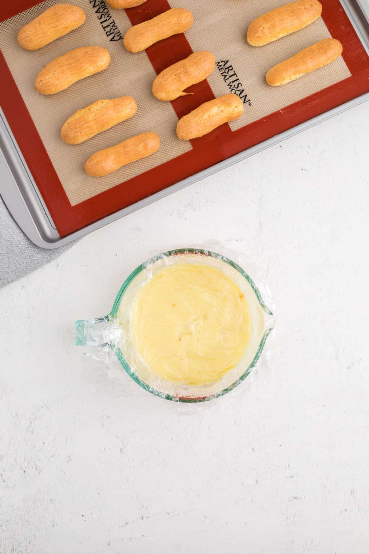 Finished vanilla pastry cream cooling in a glass container before chilling.