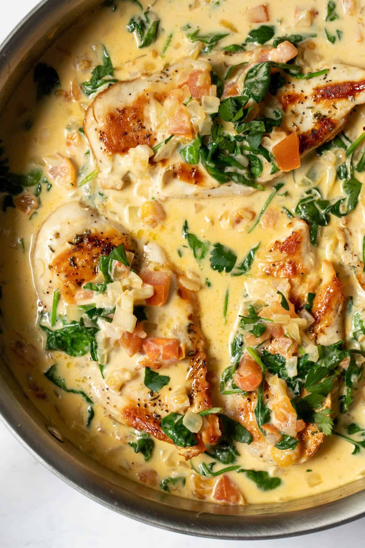 tuscan garlic chicken in a skillet with creamy sauce