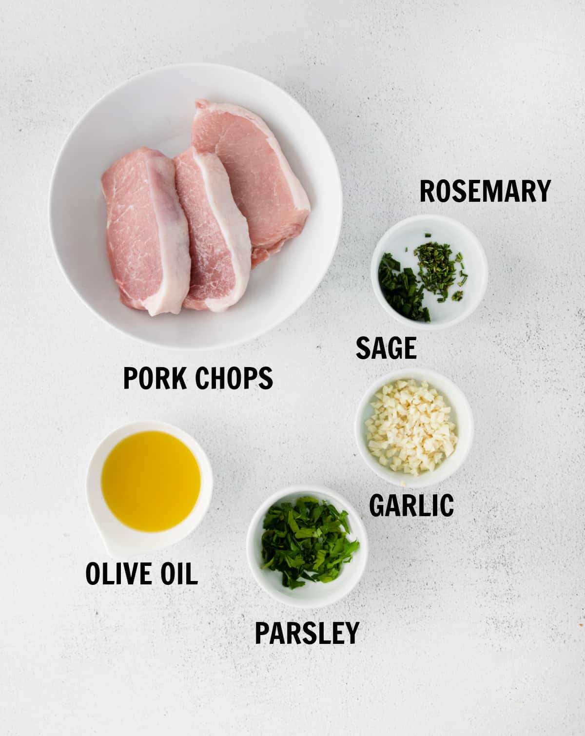 all of the ingredients for bonless pork chops on a white tabletop