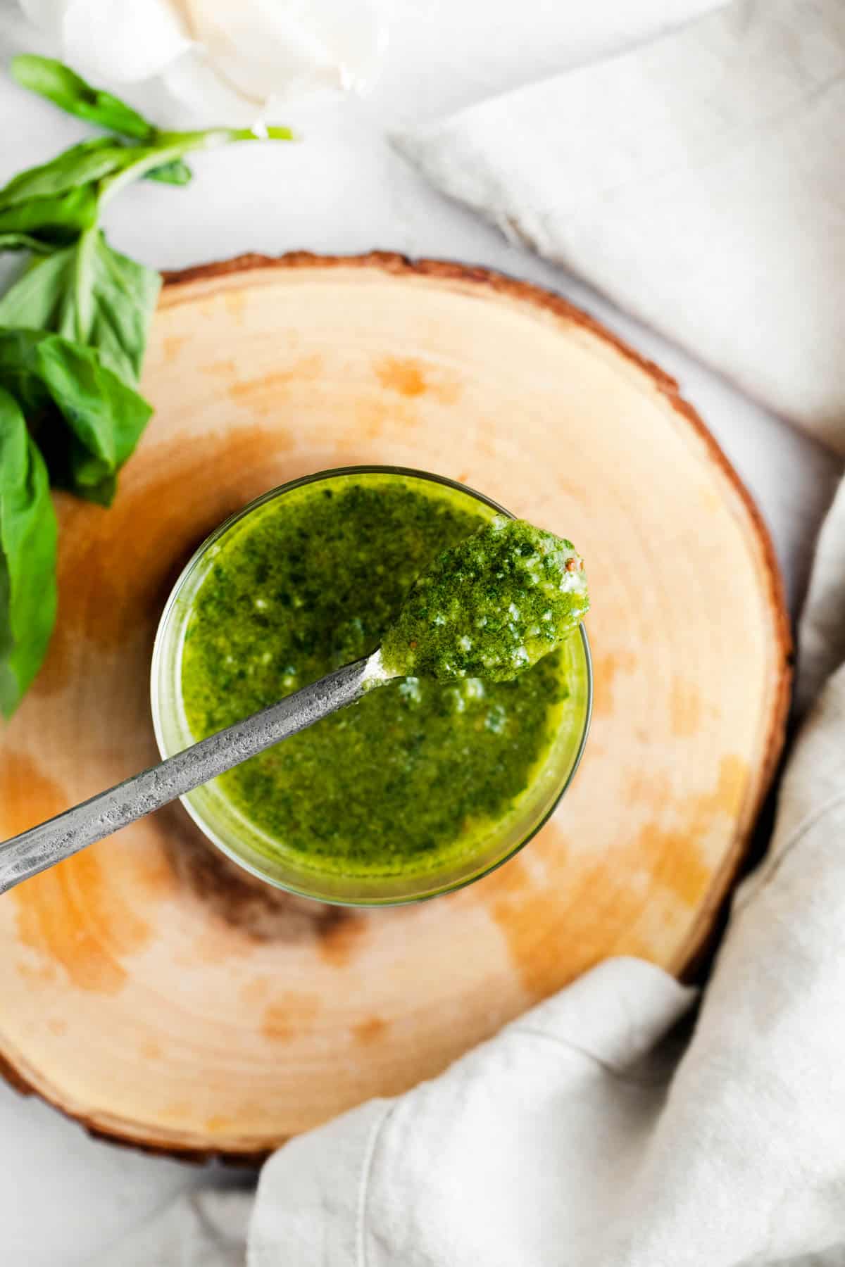 A bowl of basil pesto with a spoon
