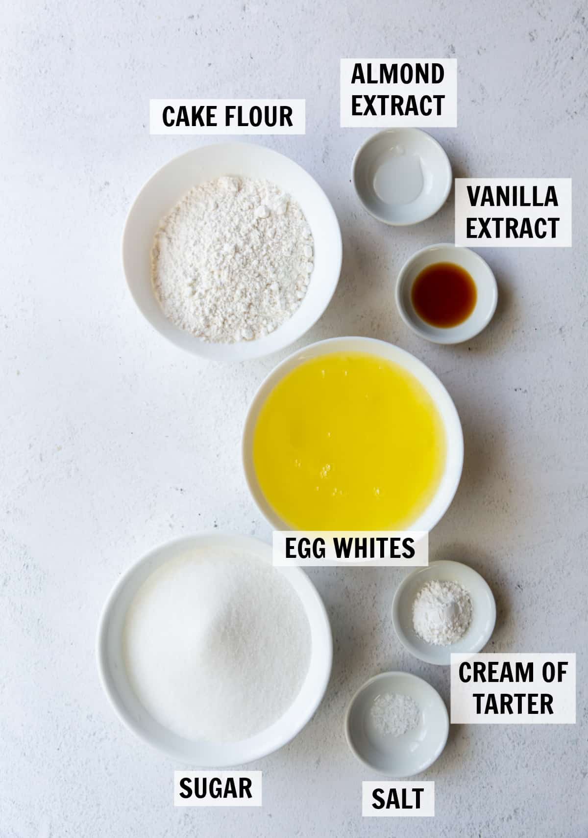 Ingredients needed to make angel food cake measured in small white dishes