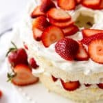 Angel food layer cake topped with strawberries and whipped cream
