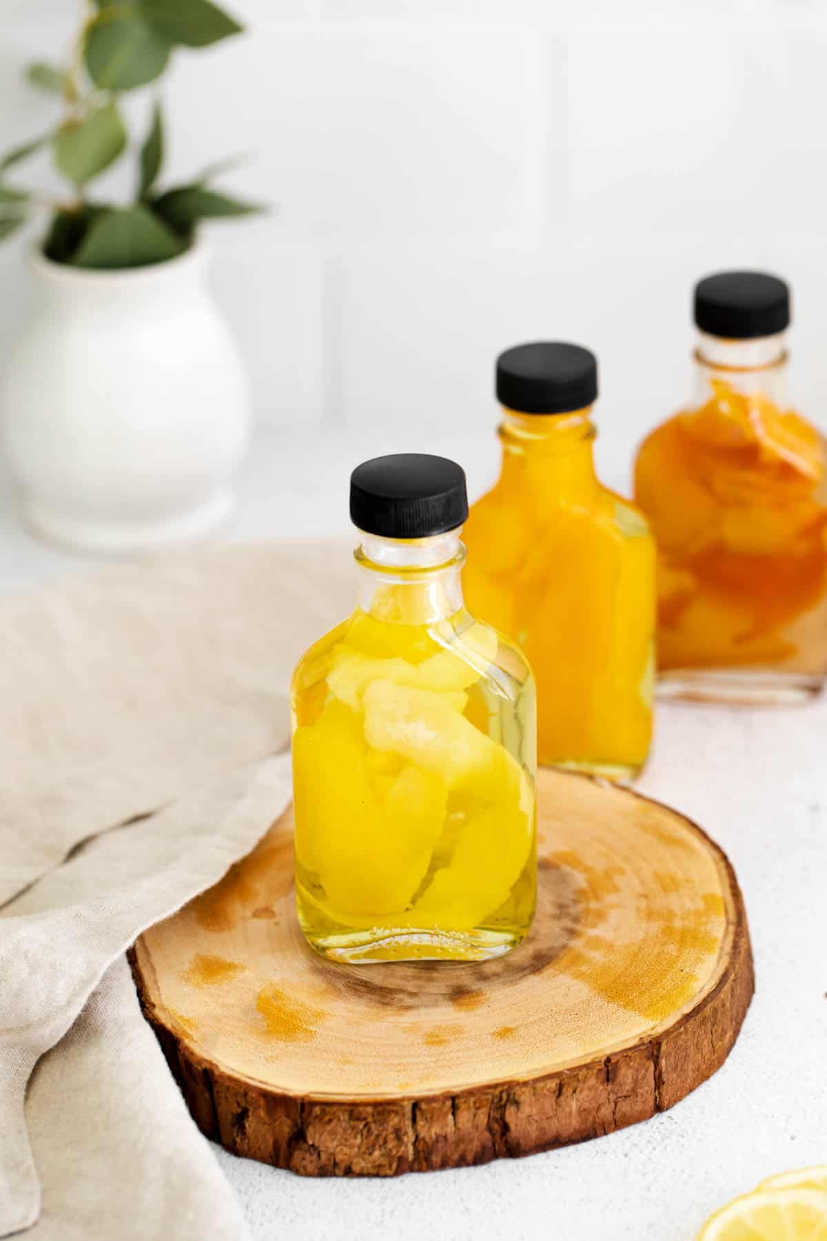 three homemade citrus extracts sitting on a tabletop