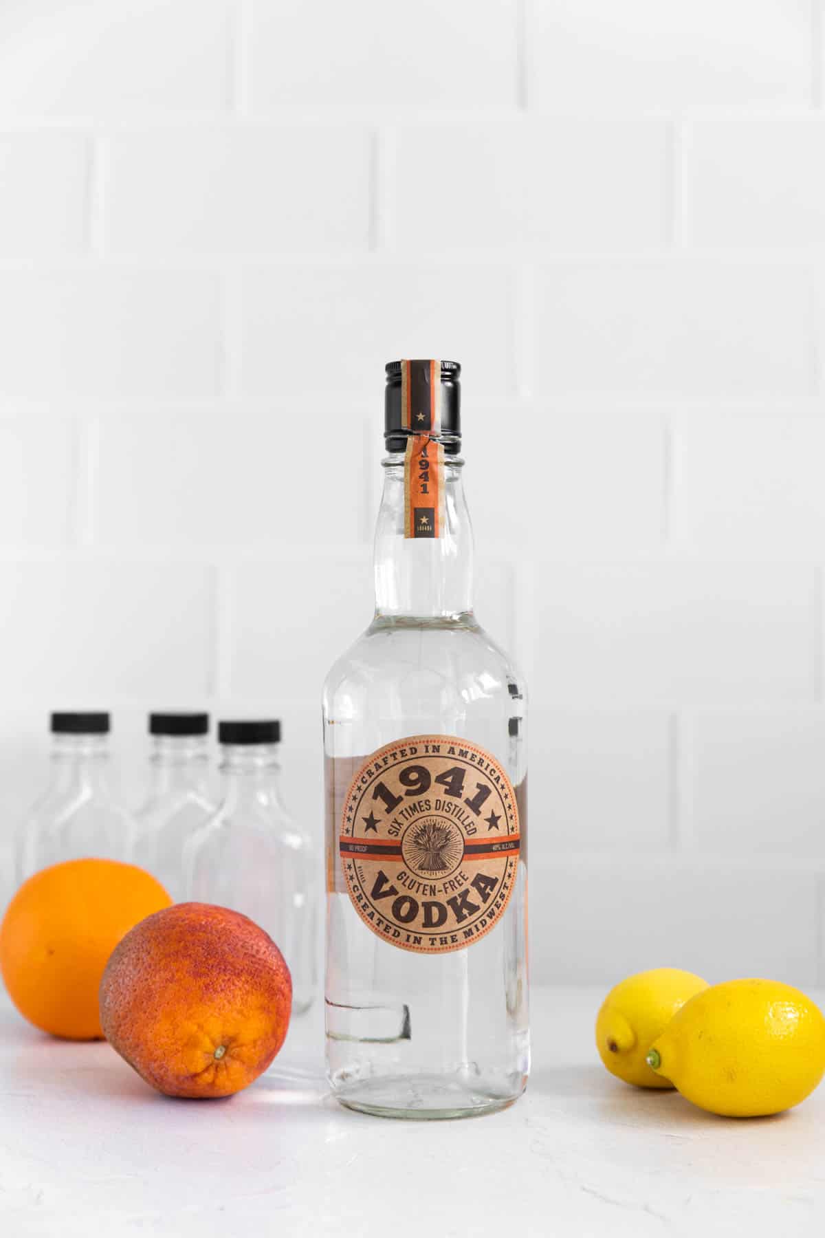 a bottle of vodka and citrus fruit for the recipe