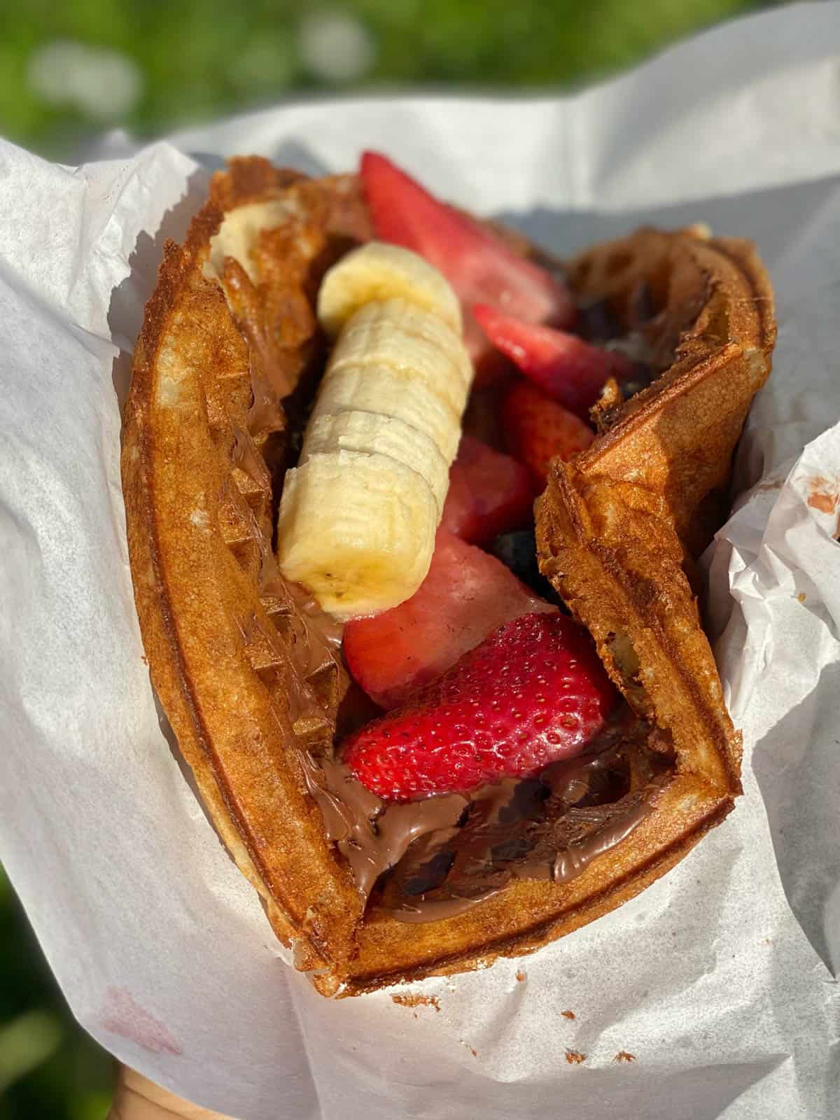 waffle topped with nutella, strawberries and bananas
