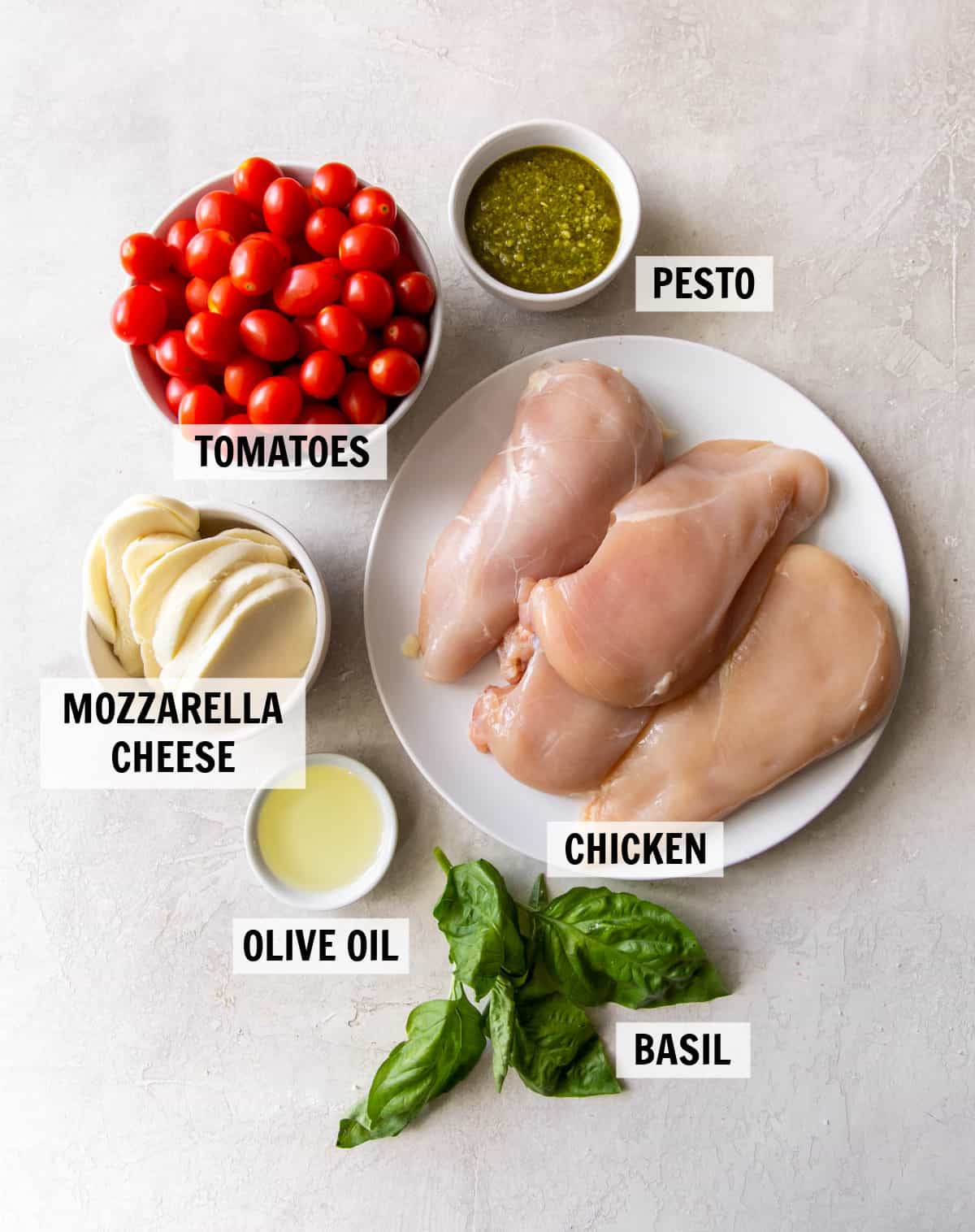 all of the ingredients for baked pesto chicken on the countertop