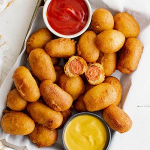 mini corn dogs on a tray with ketchup and mustard